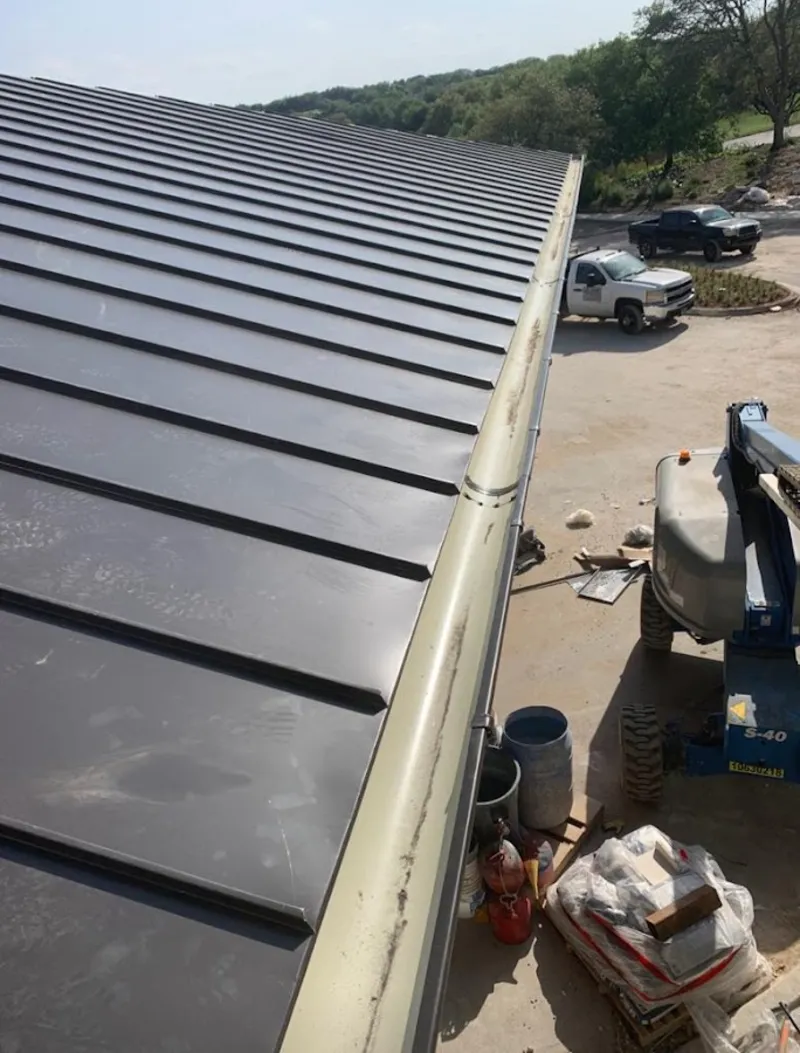 Standing seam panel and gutter detail on a metal roofing jobsite in Cedar Falls